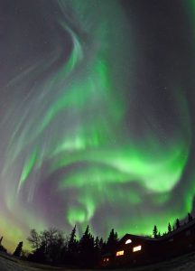 Aurora borealis over cabin in Alaska